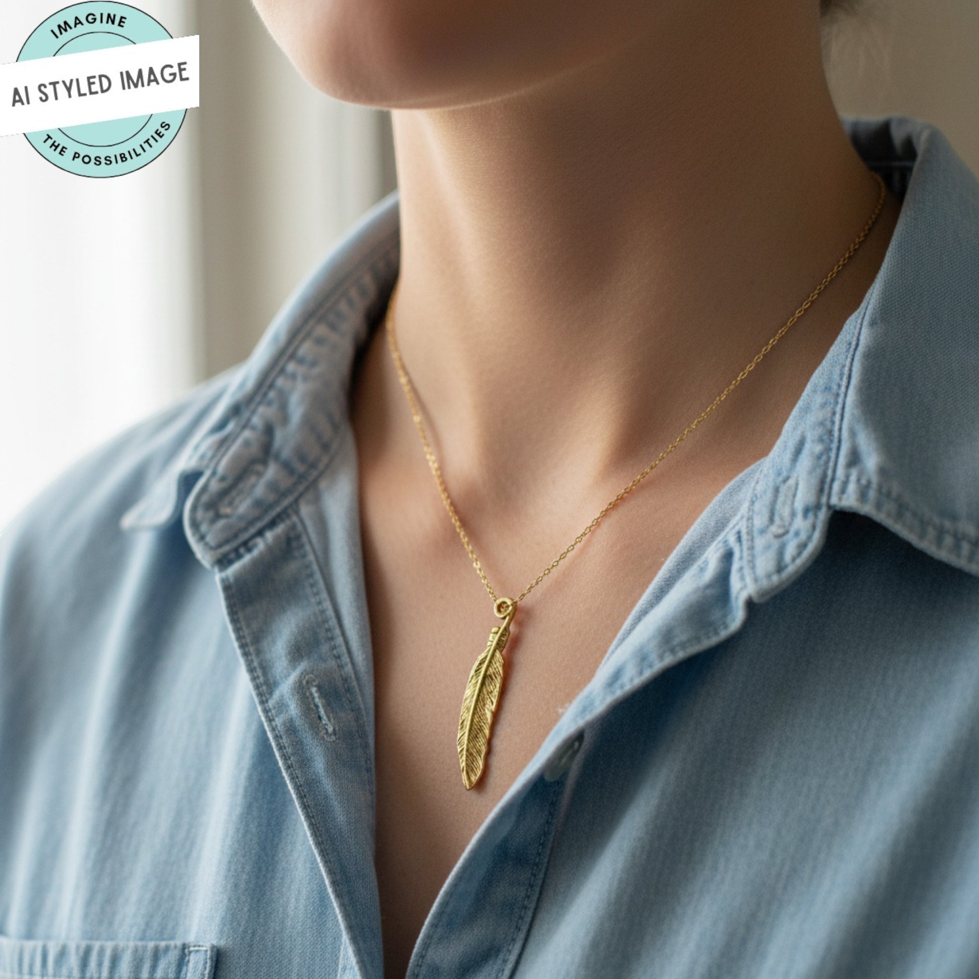 Hackberry Creek gold 24K pewter feather charm necklace on a denim shirt. Detailed texture, 33mm.