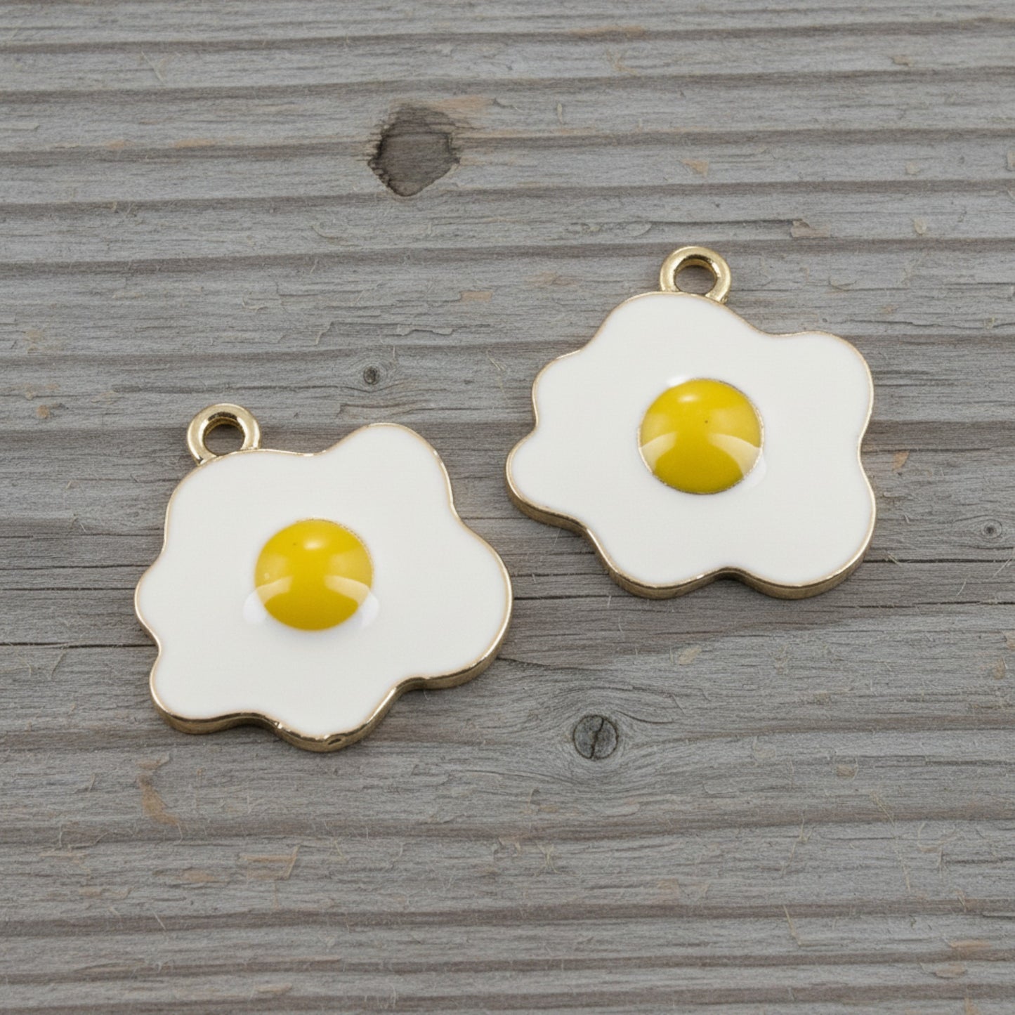 Hackberry Creek fried egg charms with white enamel and yellow yolk, featuring light gold metal edges for DIY jewelry.