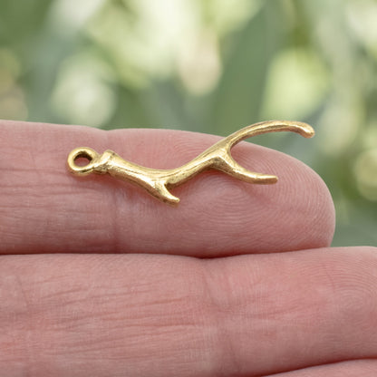 Hackberry Creek Nunn Design gold plated pewter antler charm held on a finger for scale
