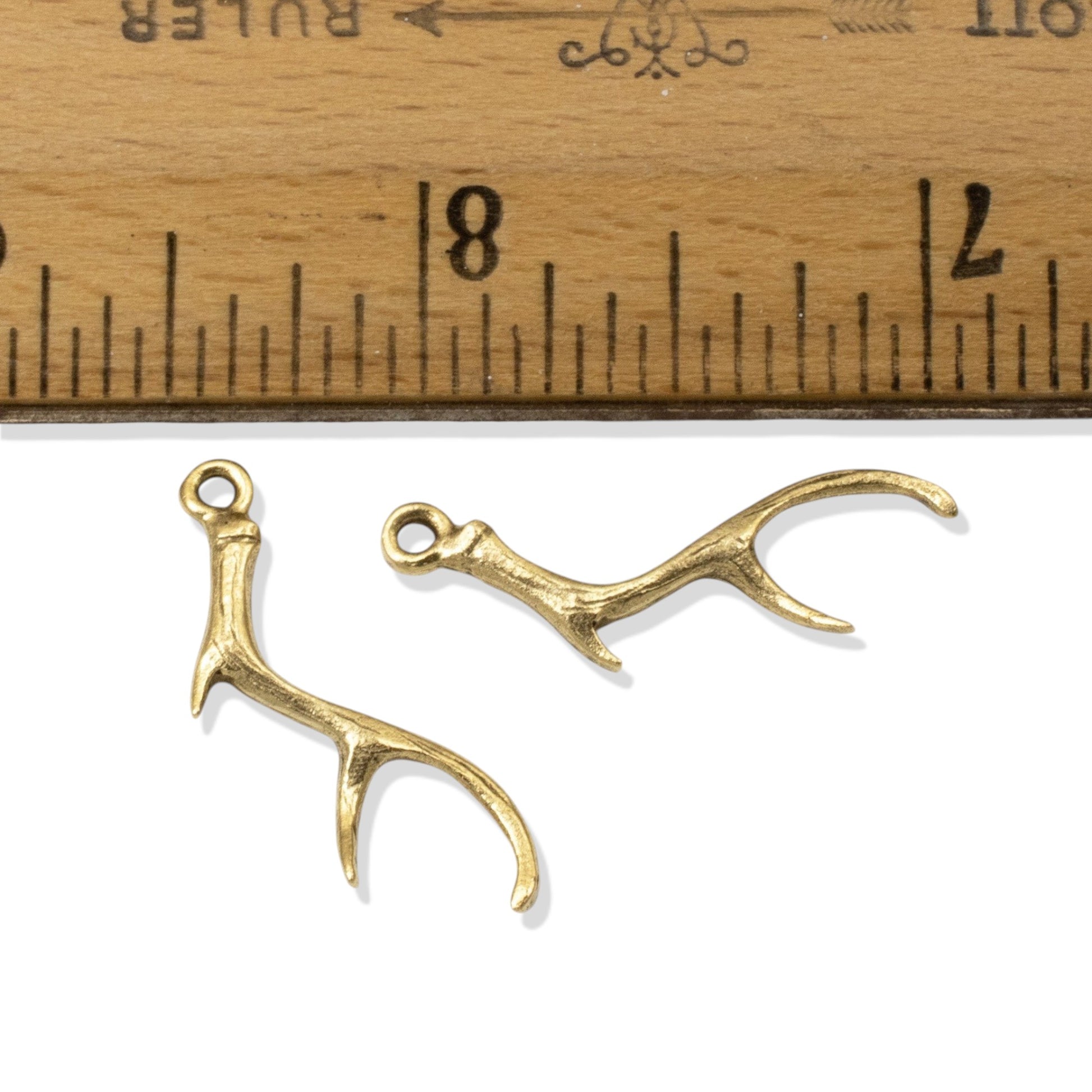 Hackberry Creek Nunn Design gold plated pewter antler charms for jewelry making shown next to a ruler for scale.