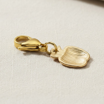 Hackberry Creek gold-plated brass apple charm showing the plain textured reverse side with a secure lobster clasp.