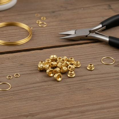 Hackberry Creek 24K gold-plated pewter beaded bead caps for jewelry making on a rustic wooden table with tools.