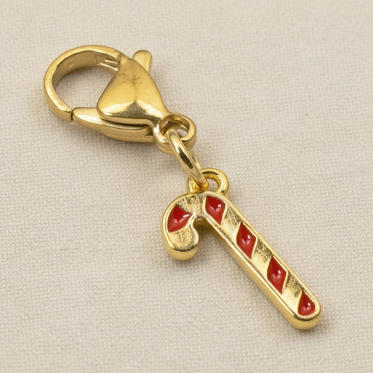Hackberry Creek 24k gold-plated candy cane charm with red enamel stripes and a secure lobster clasp for bracelets.
