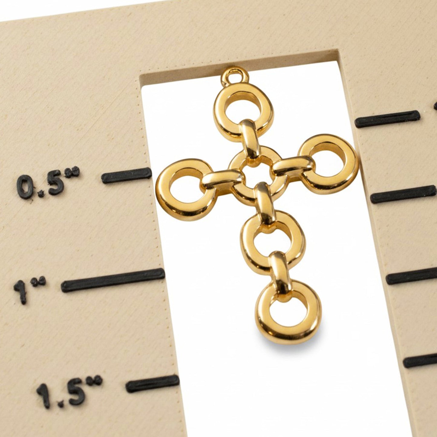 Hackberry Creek 24K gold plated open chain-link cross pendant charm for jewelry making on a measurement scale.