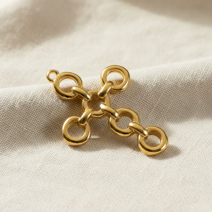 Hackberry Creek 24K gold plated cross pendant featuring an architectural open chain-link design on textured fabric.