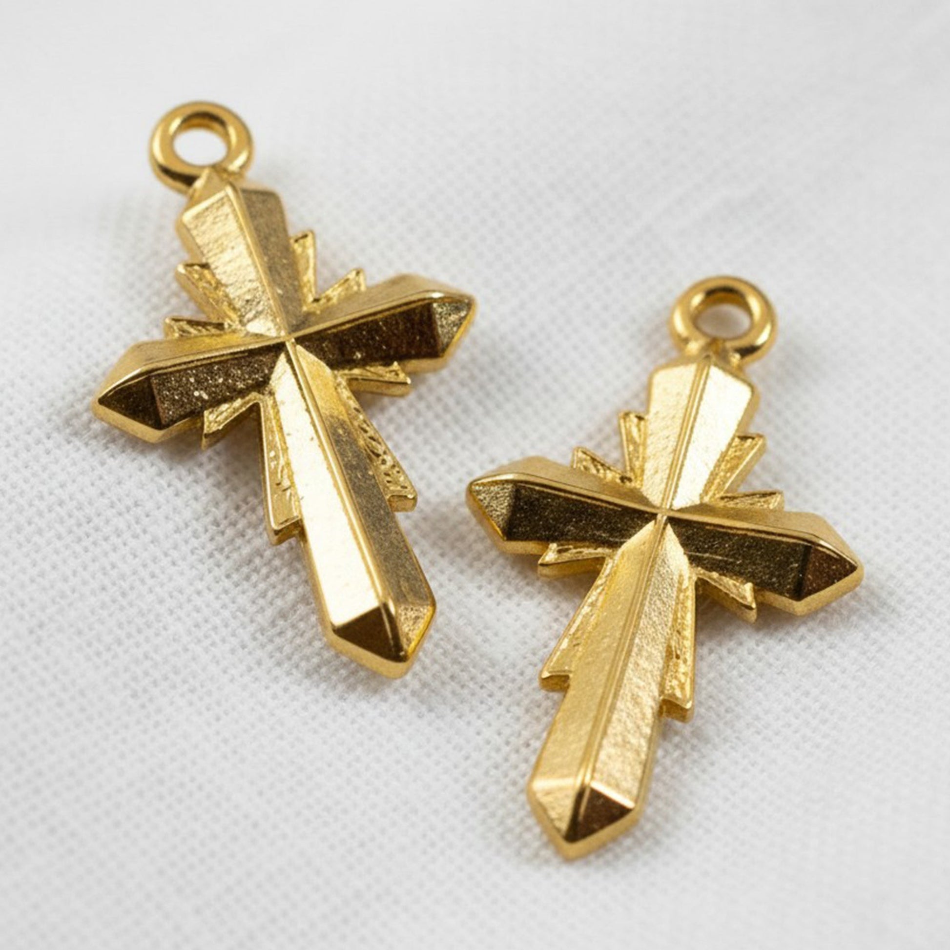 Hackberry Creek gold plated geometric cross pendants with faceted surfaces. 24K gold plated Zamak, 15x25mm.