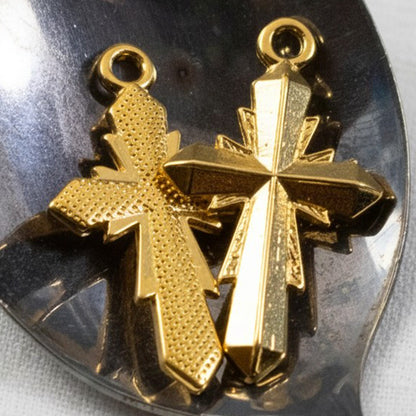 Hackberry Creek two 24K gold plated geometric cross pendants with faceted surfaces and textured detail.