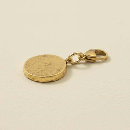Hackberry Creek gold crown charm with an antique finish and a secure lobster clasp on a neutral textured background.
