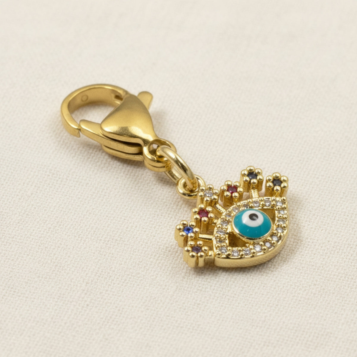 Hackberry Creek gold evil eye charm with blue enamel, clear and colorful CZ accents, and a lobster claw clasp.