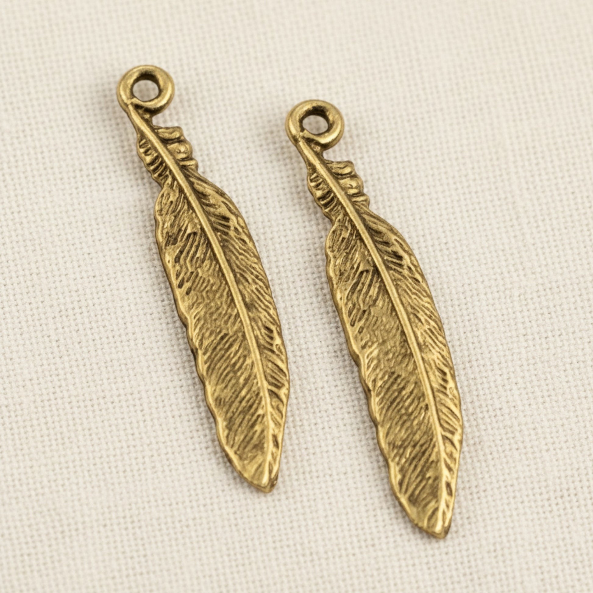 Hackberry Creek two 33mm gold 24K pewter feather charms with intricate texture and a loop for jewelry making.