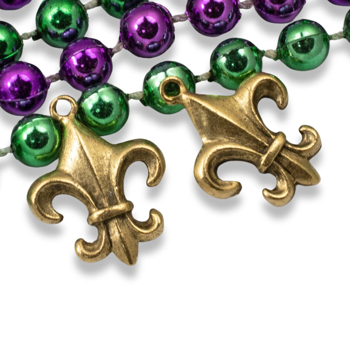 Hackberry Creek gold fleur de lis charms with antique finish displayed with purple and green Mardi Gras beads