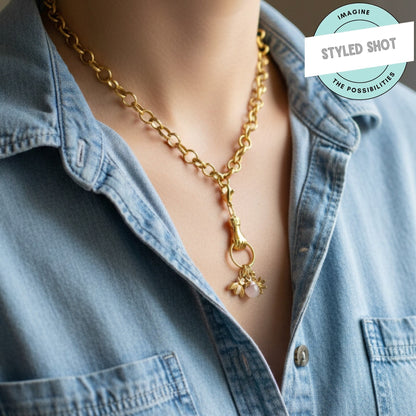 Hackberry Creek gold plated hand charm holder necklace with bee and rose quartz charms on a denim shirt.