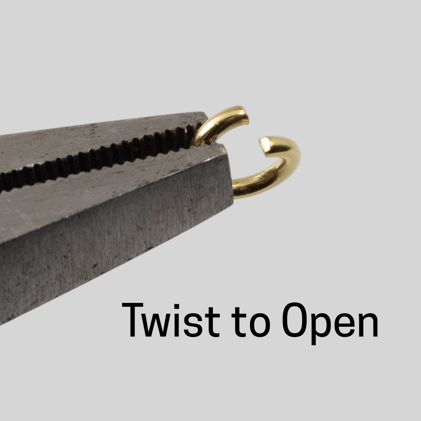 Hackberry Creek 8mm bright gold stainless steel jump ring held in pliers, demonstrating how to twist to open.