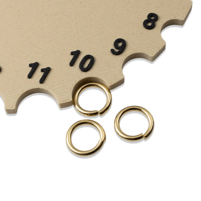 Hackberry Creek 10mm bright gold stainless steel jump rings displayed next to a size gauge tool