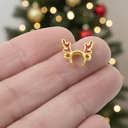 Hackberry Creek 24k gold plated reindeer antler jewelry connector with red enamel details held in hand