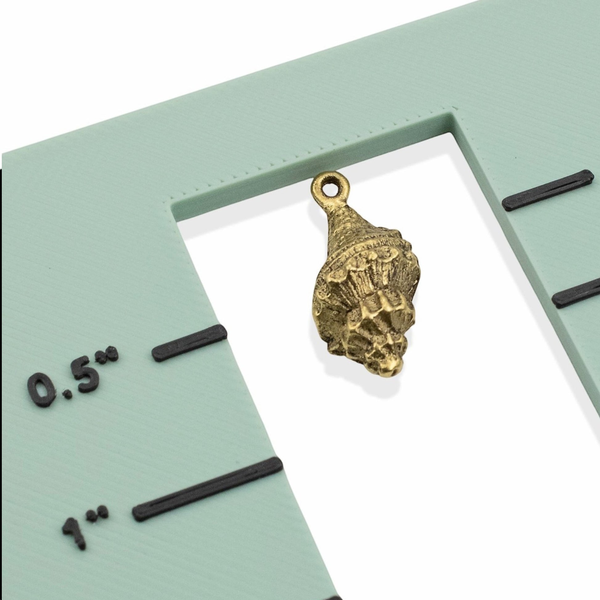 Hackberry Creek 24K gold plated pewter trumpet shell charm with intricate detailing and a loop for jewelry making.