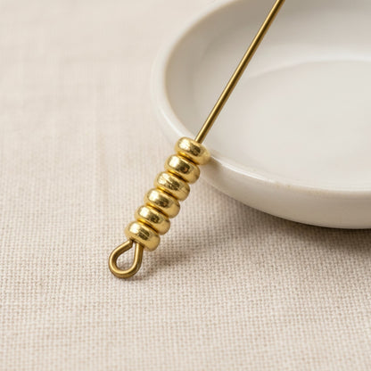 Hackberry Creek 3mm gold heishi disc spacer beads made of 24K-plated pewter. Smooth, round beads on a jewelry wire.