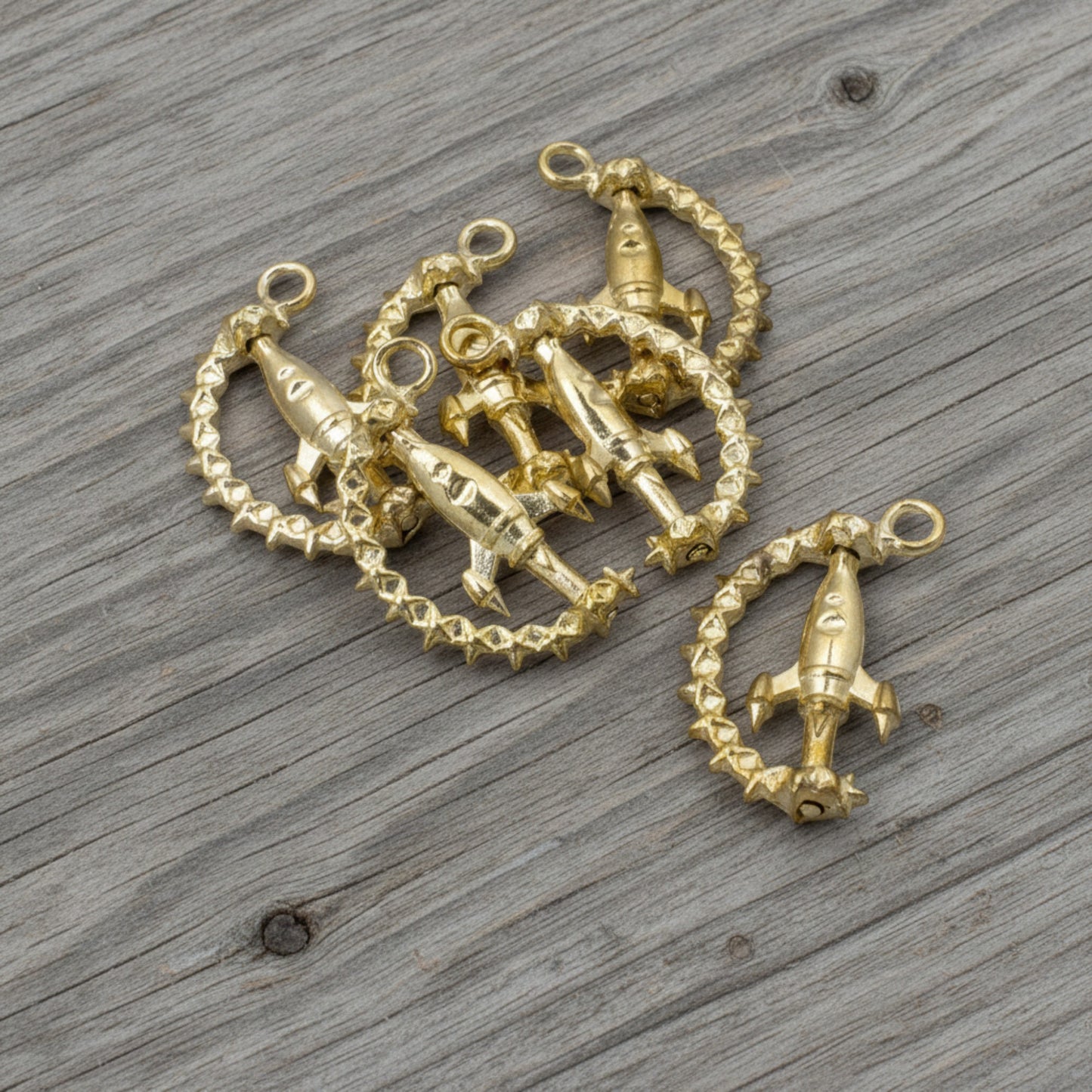 Hackberry Creek gold alloy spinning rocket charms with star-detailed rings for space-themed jewelry making.