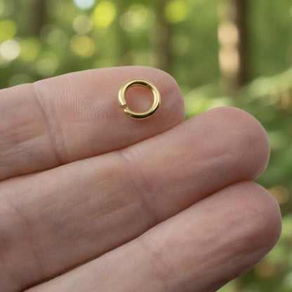 Hackberry Creek 8mm bright gold plated 304 stainless steel heavy duty jump ring held on a finger