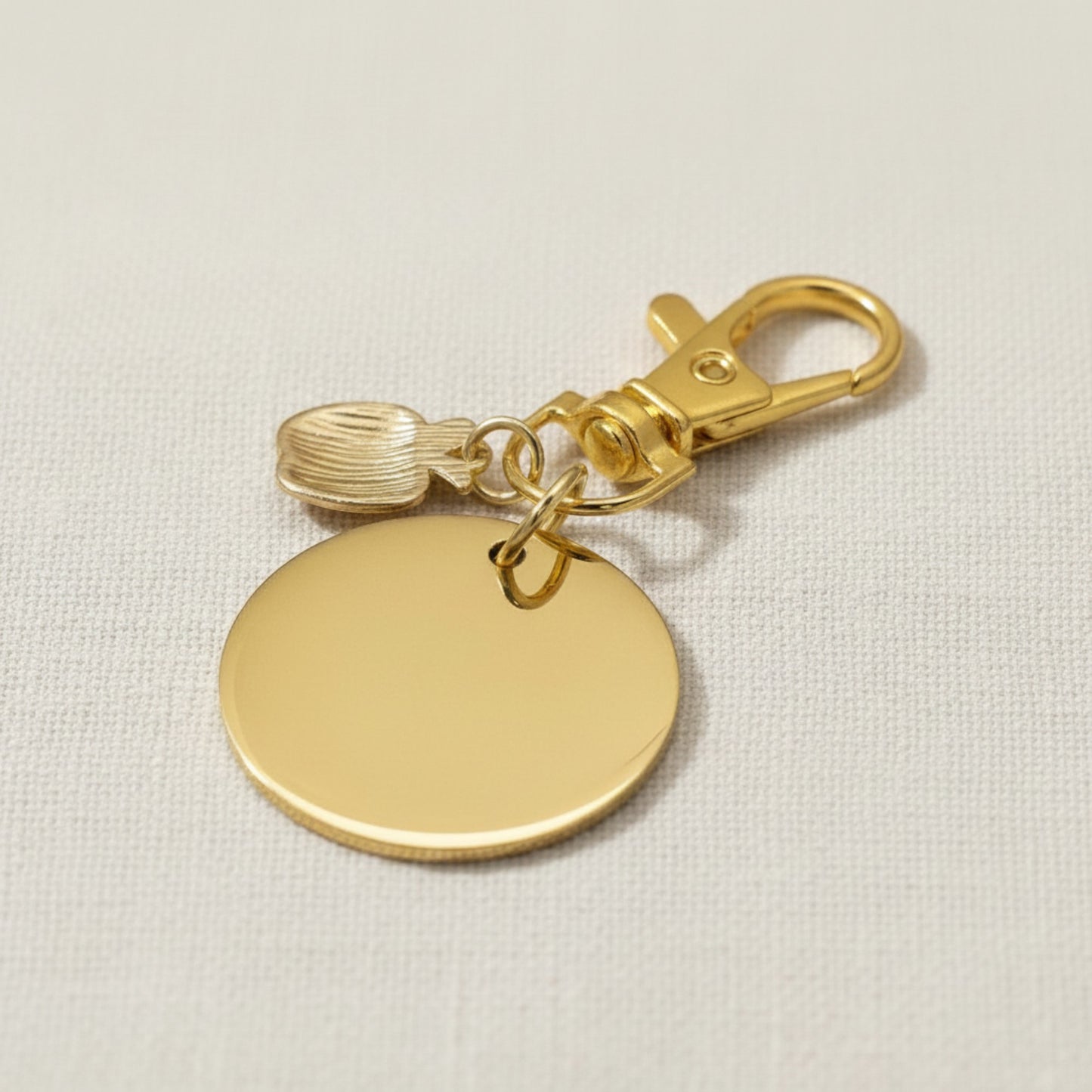 Hackberry Creek gold stainless steel teacher bag charm with apple accent and swivel clasp on a neutral background.