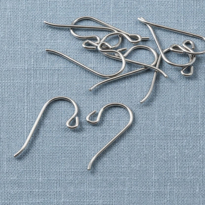 Hackberry Creek hypoallergenic gray niobium French hook ear wires with small loops on a blue fabric background.