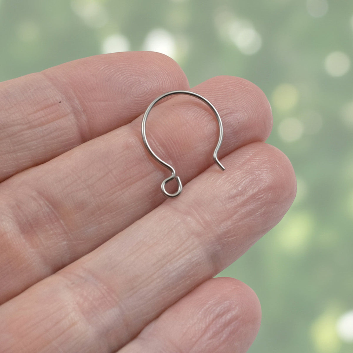 Hackberry Creek gray niobium circle hoop ear wire held in hand, showcasing the 15mm hypoallergenic geometric design.