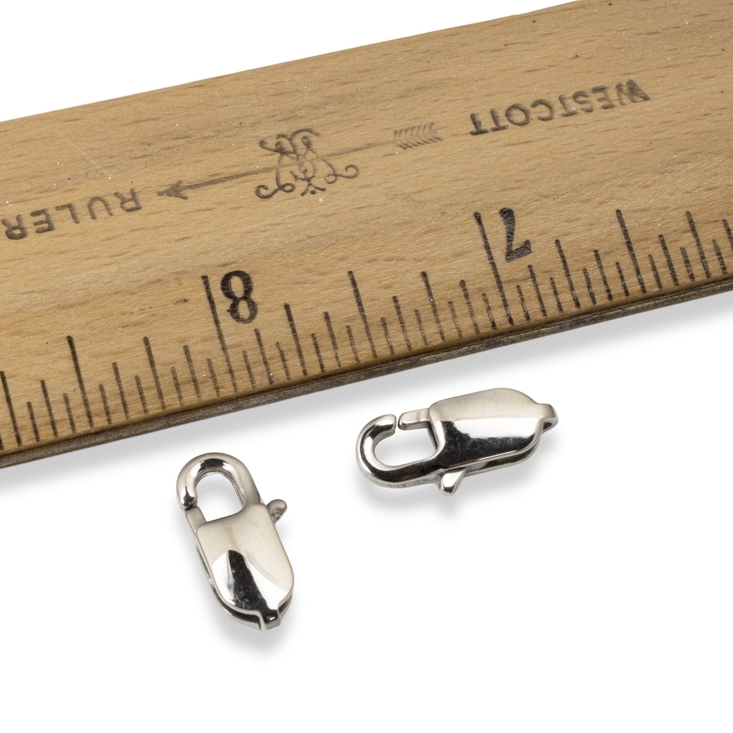 Hackberry Creek large oval silver stainless steel lobster claw clasps next to a ruler for scale