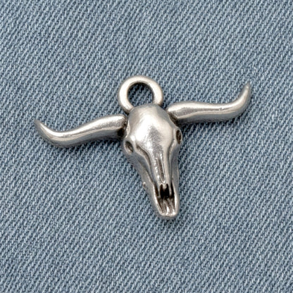 Hackberry Creek antique silver longhorn steer skull charm for southwestern boho jewelry making on denim background