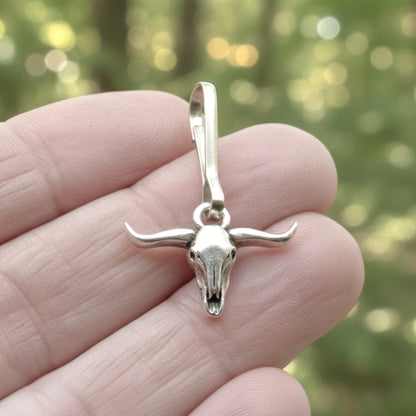 Hackberry Creek silver-plated pewter longhorn steer skull zipper charm with stainless steel clasp held in hand.
