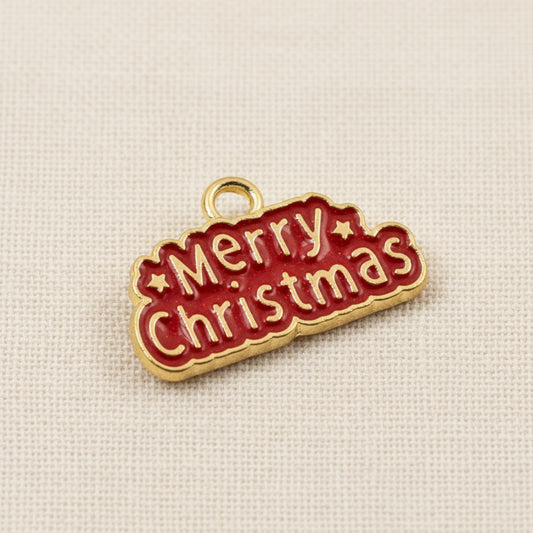 Hackberry Creek gold-plated metal alloy charm with red enamel Merry Christmas text for holiday jewelry making.