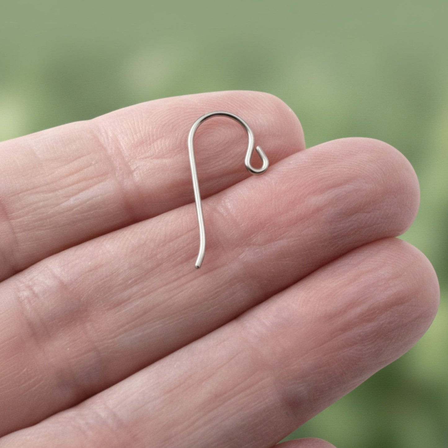 Hackberry Creek hypoallergenic gray niobium French hook ear wire with a small loop held in a hand