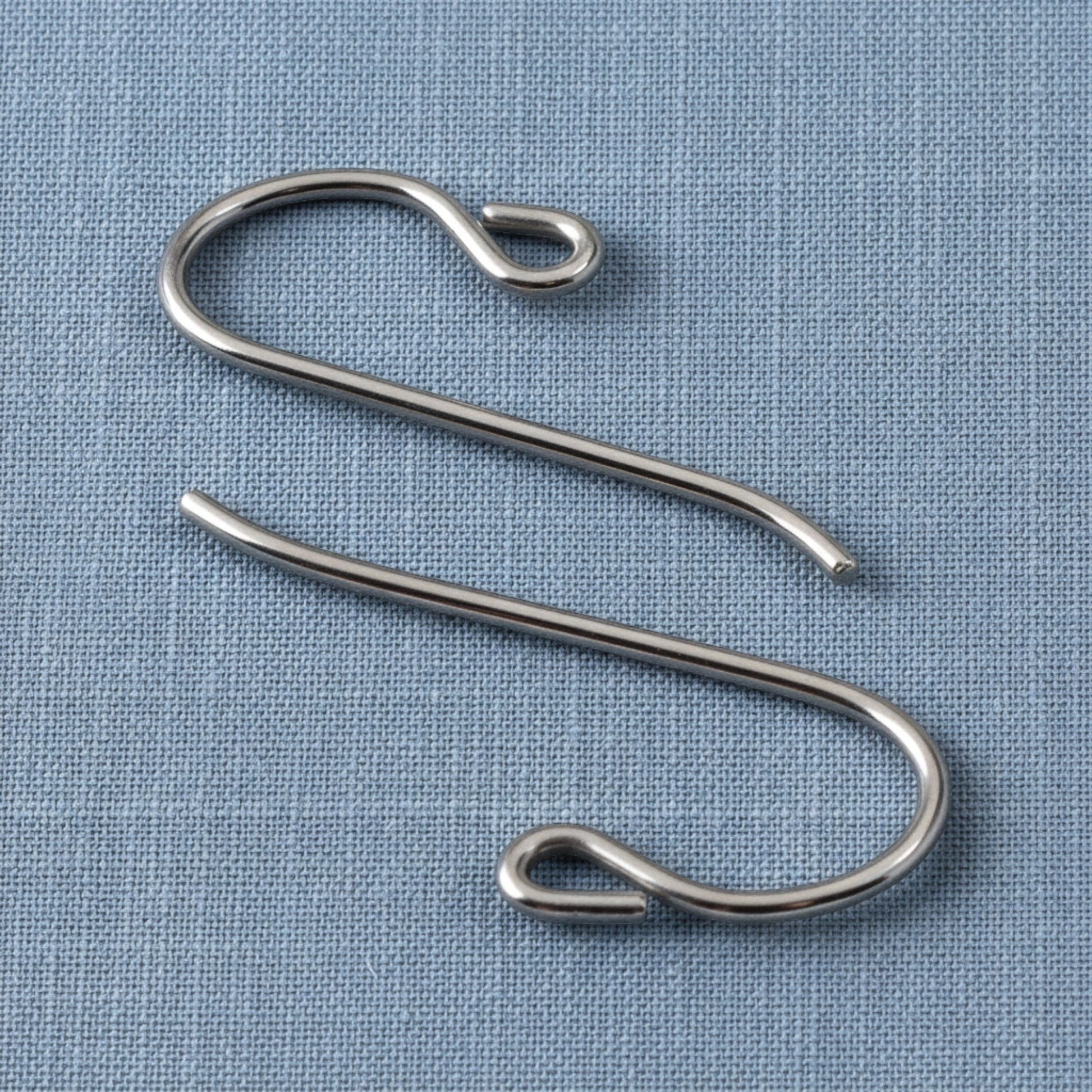 Hackberry Creek hypoallergenic gray niobium French hook ear wires with small loops on a blue fabric background.