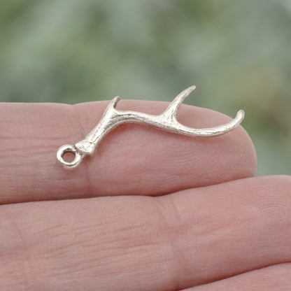 Hackberry Creek Nunn Design antique silver plated pewter antler charm held on a finger for scale