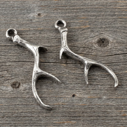 Hackberry Creek Nunn Design silver plated pewter antler charms for artisan jewelry making on a rustic wood background