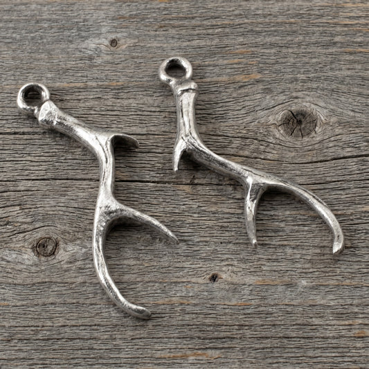 Hackberry Creek Nunn Design silver plated pewter antler charms for artisan jewelry making on a rustic wood background