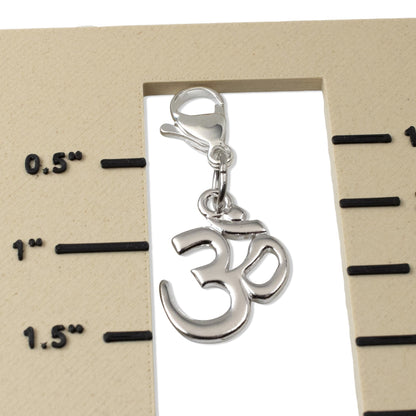 Hackberry Creek Om symbol pewter charm with silver-plated lobster clasp shown against a measuring scale