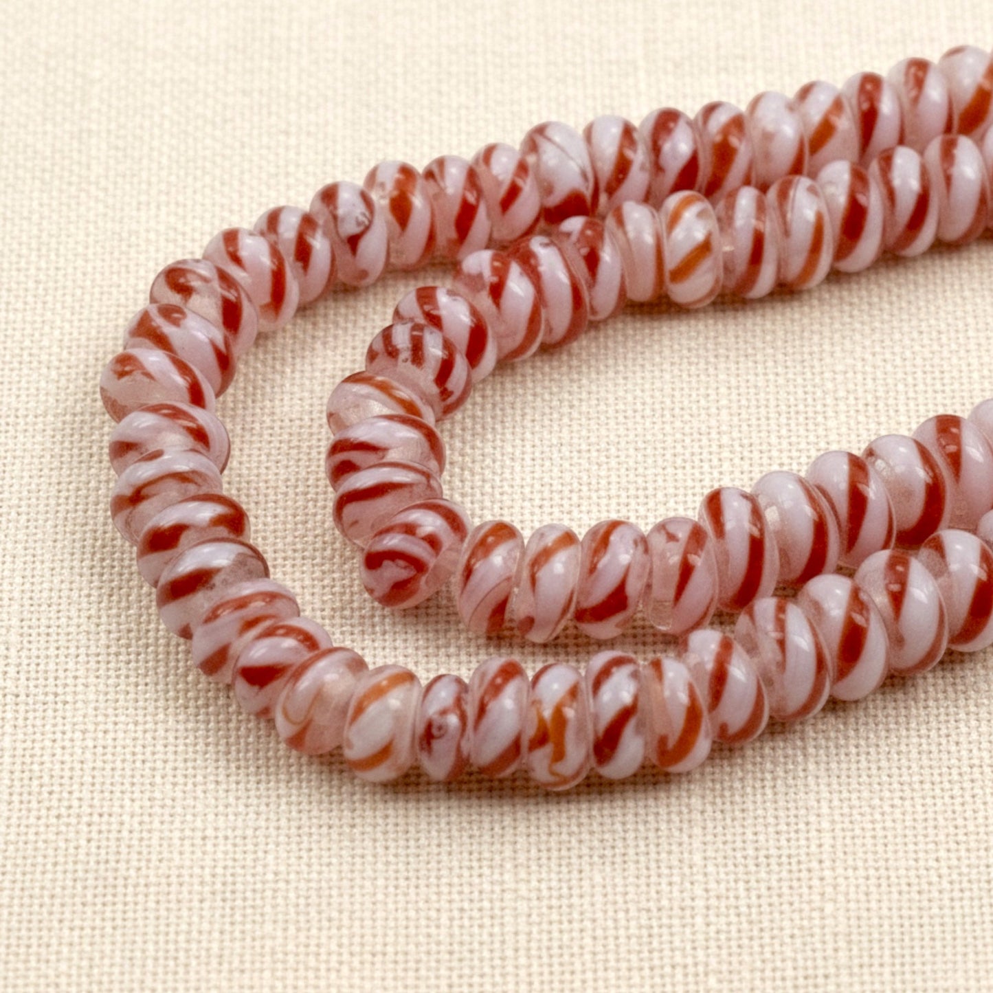 Hackberry Creek red and white peppermint stripe rondelle glass lampwork beads on a 17 inch strand for holiday jewelry