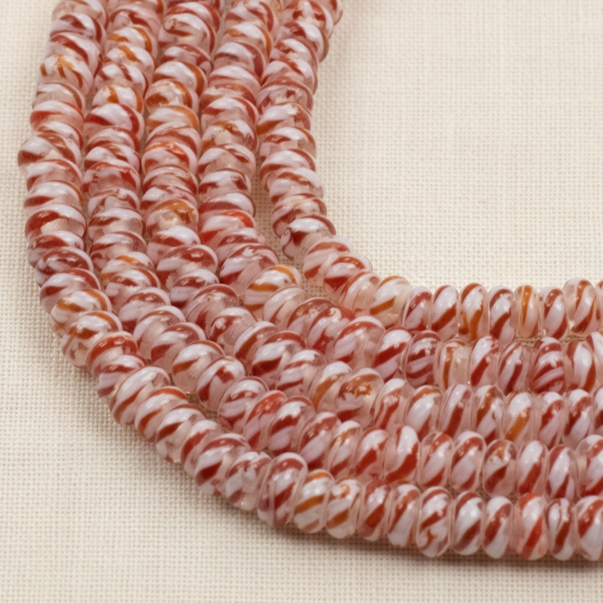 Hackberry Creek red and white peppermint stripe glass lampwork rondelle beads on a 17-inch strand for jewelry making