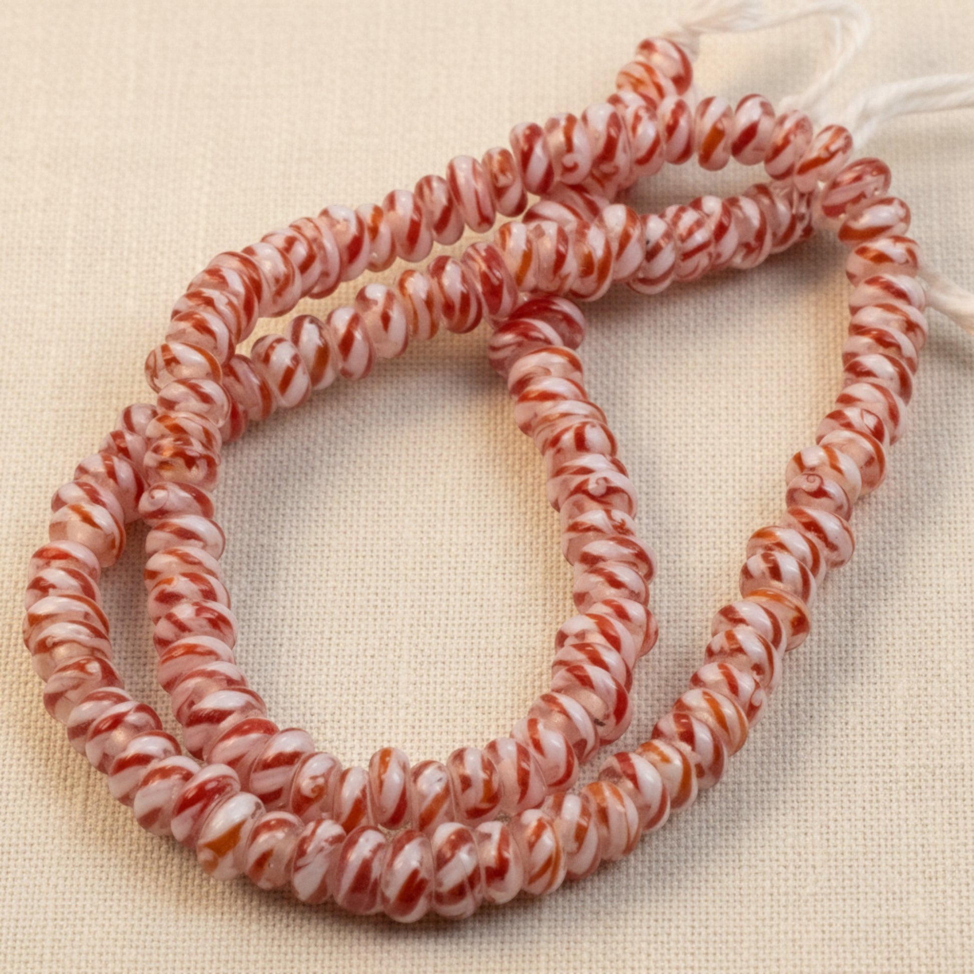 Hackberry Creek red and white peppermint stripe rondelle glass lampwork beads on a 17 inch strand for jewelry making