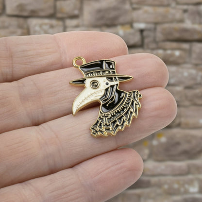 Hackberry Creek plague doctor raven head pendant in black and white enamel with gold plating held in a hand