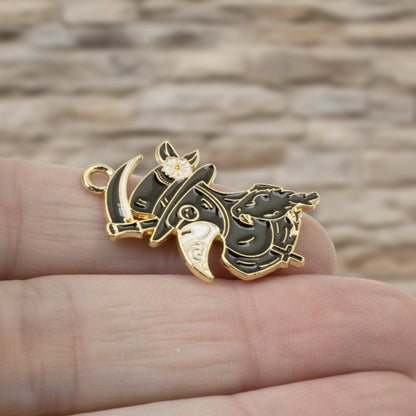Hackberry Creek plague doctor raven head charm in black and white enamel with gold plating held in hand.