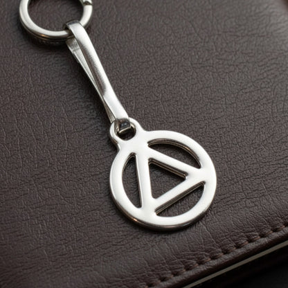 Hackberry Creek silver triangle zipper charm with stainless steel clip, symbolizing recovery and sobriety.