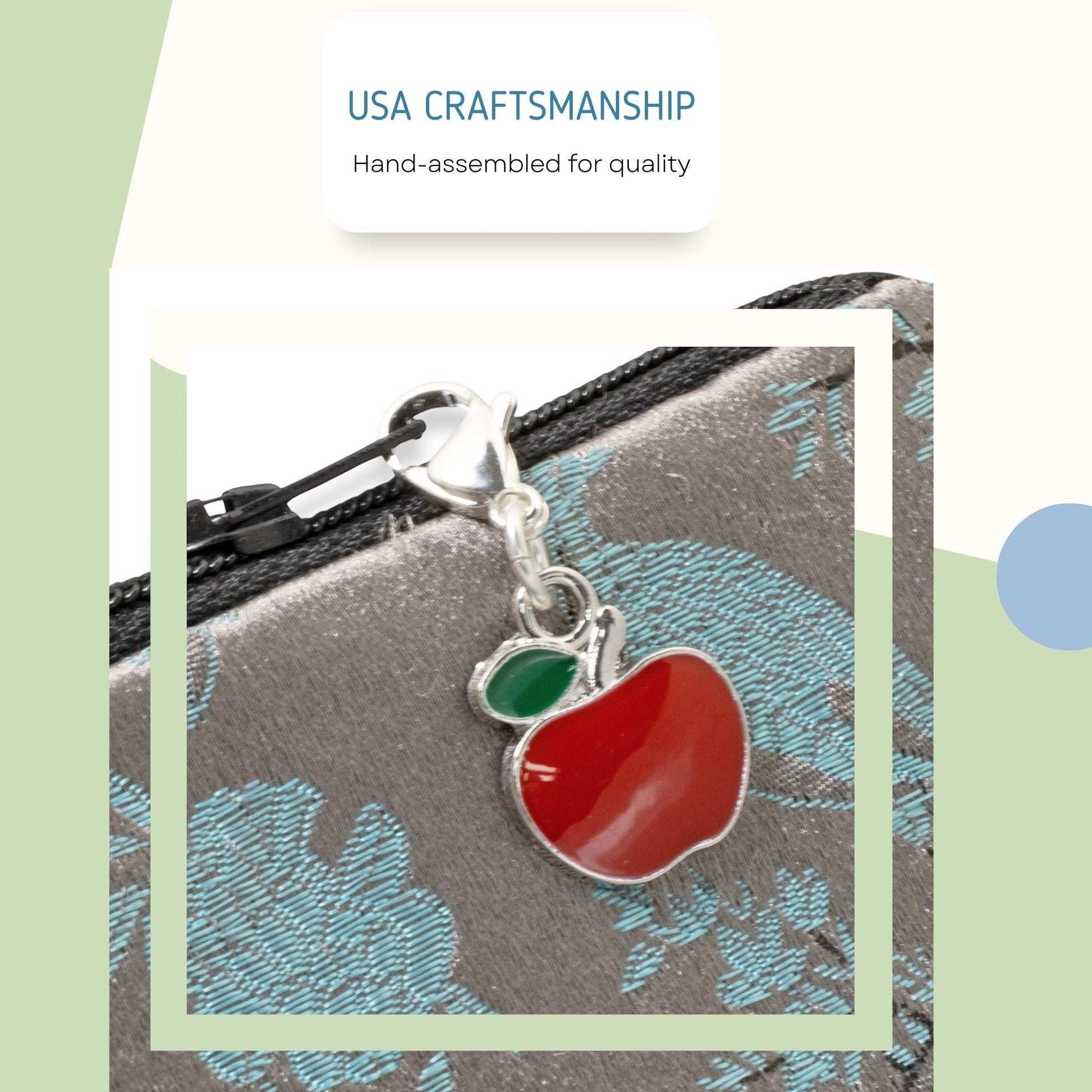 Hackberry Creek red apple charm with green leaf accent, silver-plated brass and enamel, clip-on style.