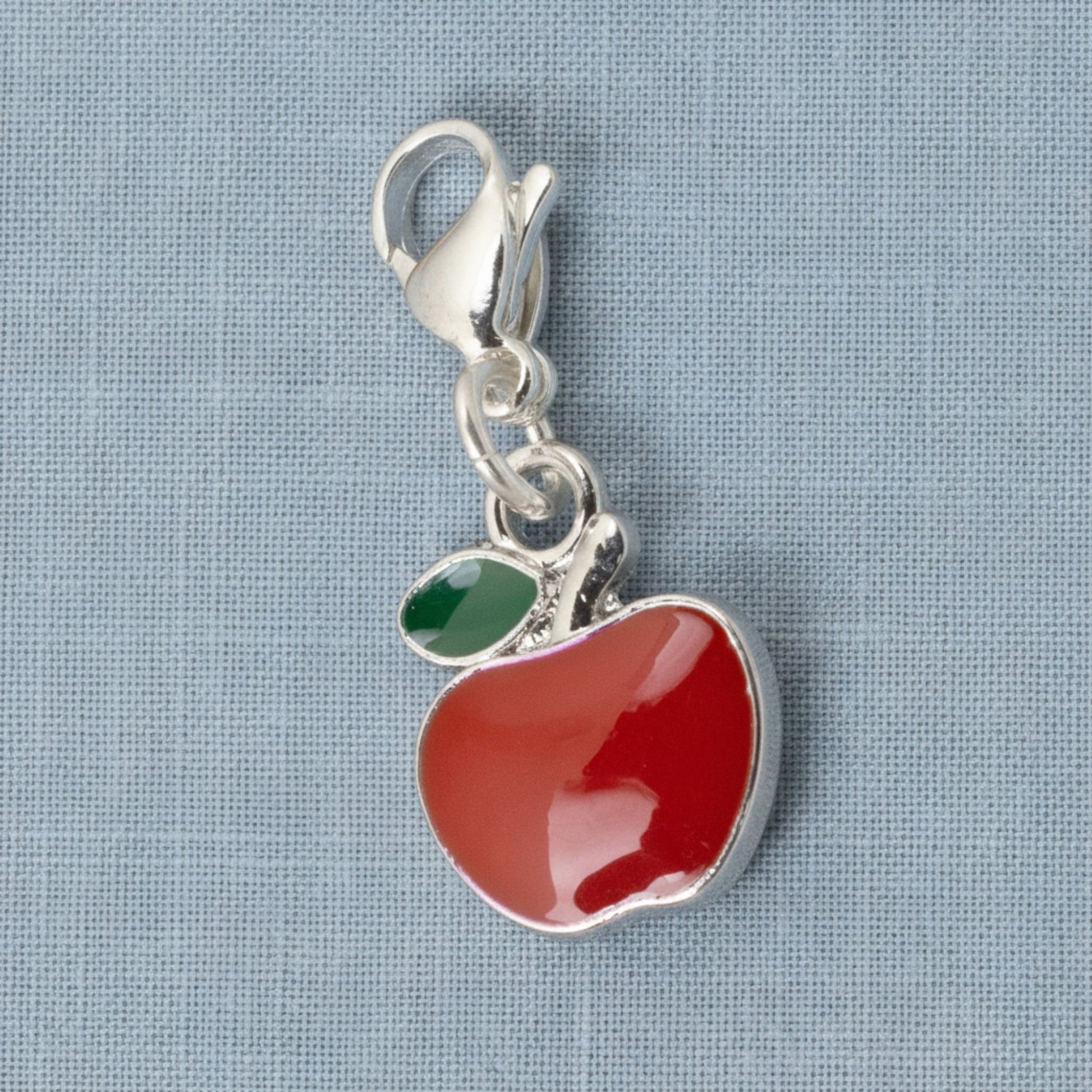 Hackberry Creek red apple charm with green leaf accent, silver-plated brass and enamel, 1 1/2" long, clip-on clasp.