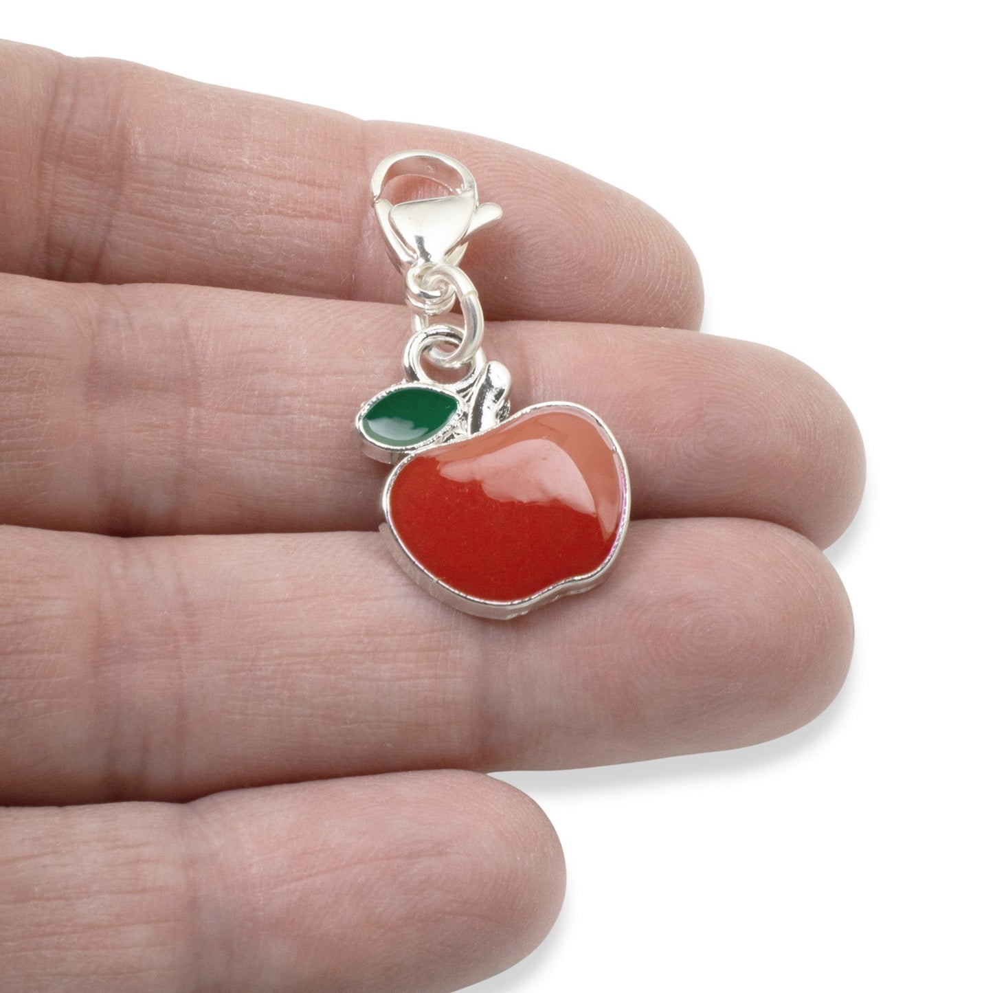 Hackberry Creek red apple charm with green leaf accent, silver-plated brass and enamel. Clip-on clasp.