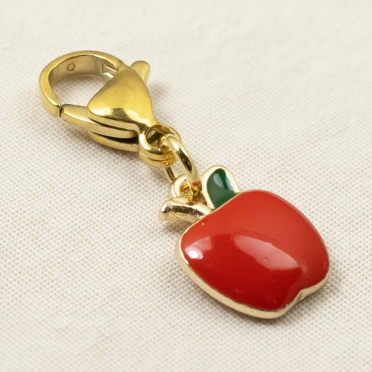 Hackberry Creek red apple charm with green enamel leaf and gold-plated brass clasp for bags or jewelry.