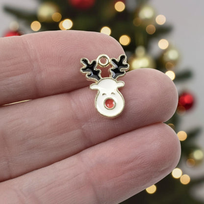 Hackberry Creek enamel reindeer charm with white face, red nose, and black antlers on gold-plated metal for jewelry