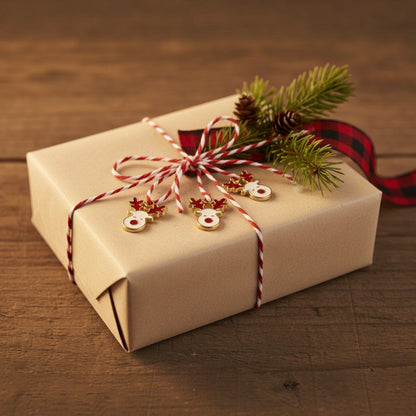 Hackberry Creek reindeer charms with white enamel, red nose, and gold-plated antlers on a festive gift box.