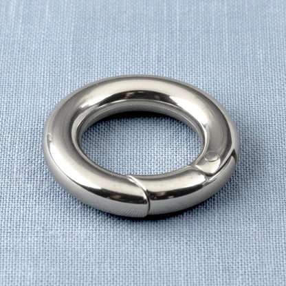 Hackberry Creek 15mm round stainless steel carabiner spring clasp with a polished silver finish on a blue fabric base.