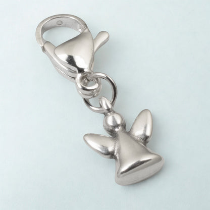 Hackberry Creek silver guardian angel charm with a stainless steel lobster clasp on a light blue background.